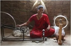 Indian rural woman artisan weaving khadi in chakhra.